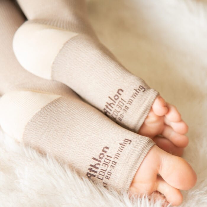 Guantes de compresión para bebés en color beige, suaves y cómodos.